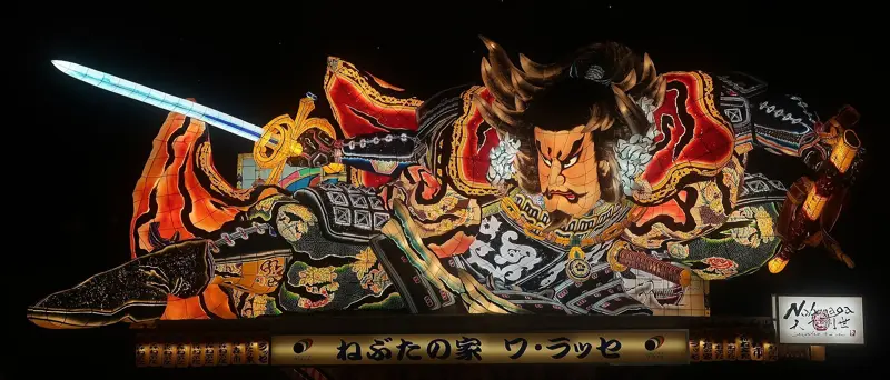 A glowing Nebuta festival float of a warrior