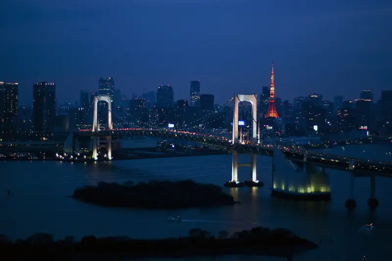 Rainbow Bridge over Tokyo Bay at night with Tokyo Tower behind