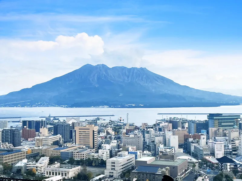 Sakurajima volcano looming over Kagoshima city at blue hour