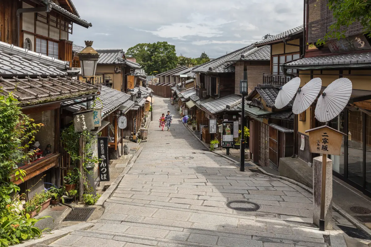 Pedestrian road with pavements, paper umbrellas and people in yukata, Higashiyama-ku, Kyoto, Japan