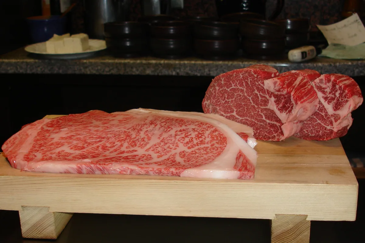 Raw marbled Kobe beef on a wooden board, ready for the grill
